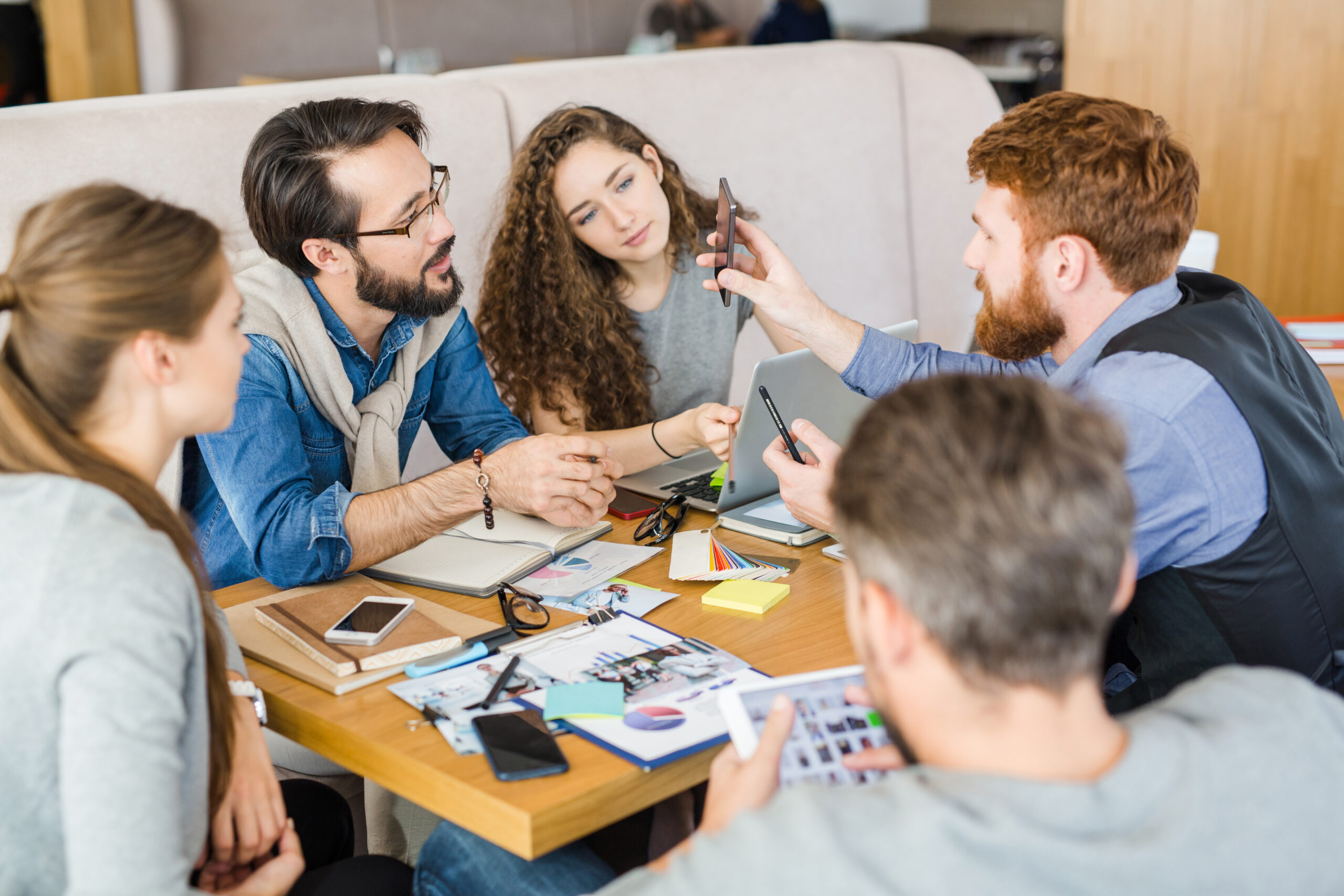 Look at this Young designer showing his colleagues something curious in smartphone